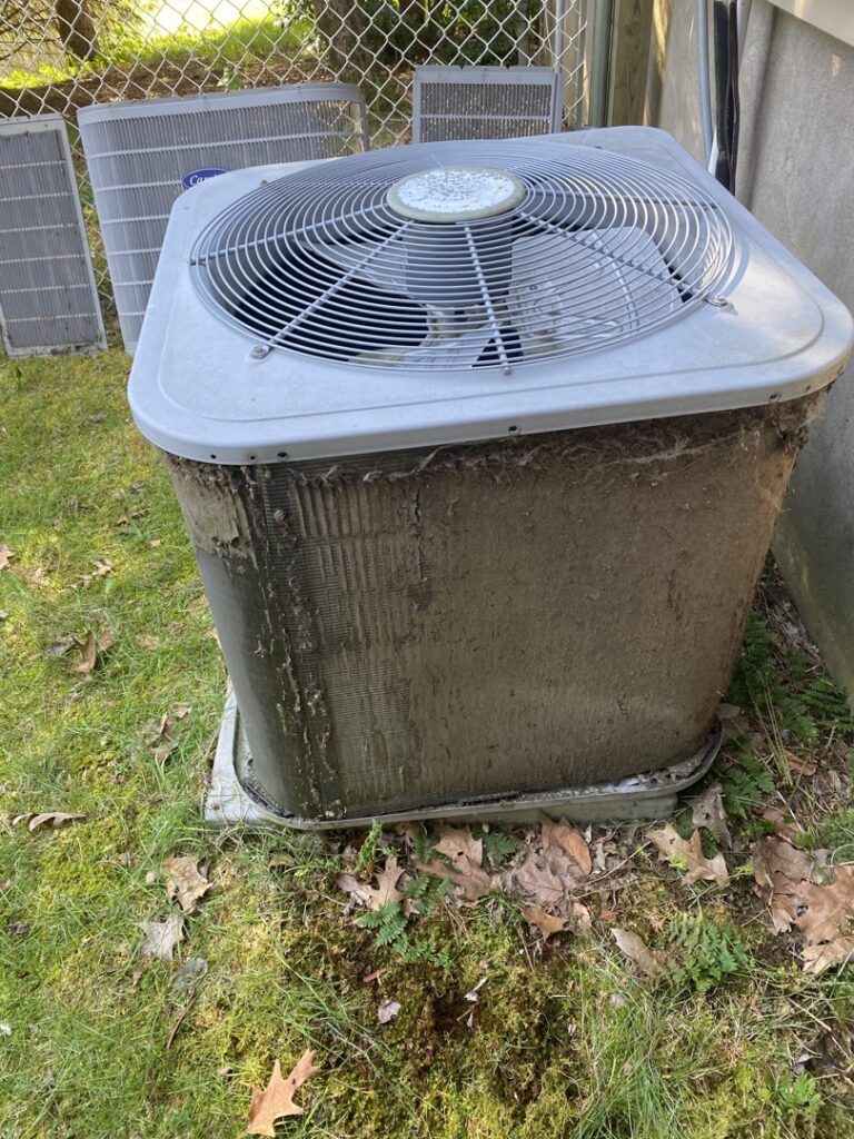 A very dirty outdoor AC unit with panels removed, showing clogged coils, ready for cleaning by Kane Heating & Air in Mountain Top, PA.