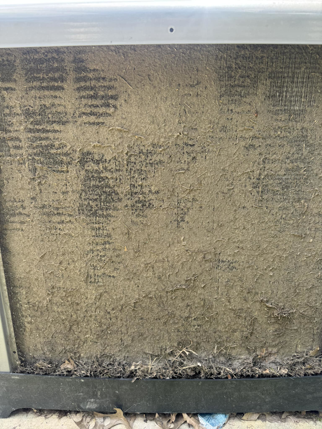 A severely dirty outdoor AC unit coil needing service from Air Control Heating & Air in Central City, LA