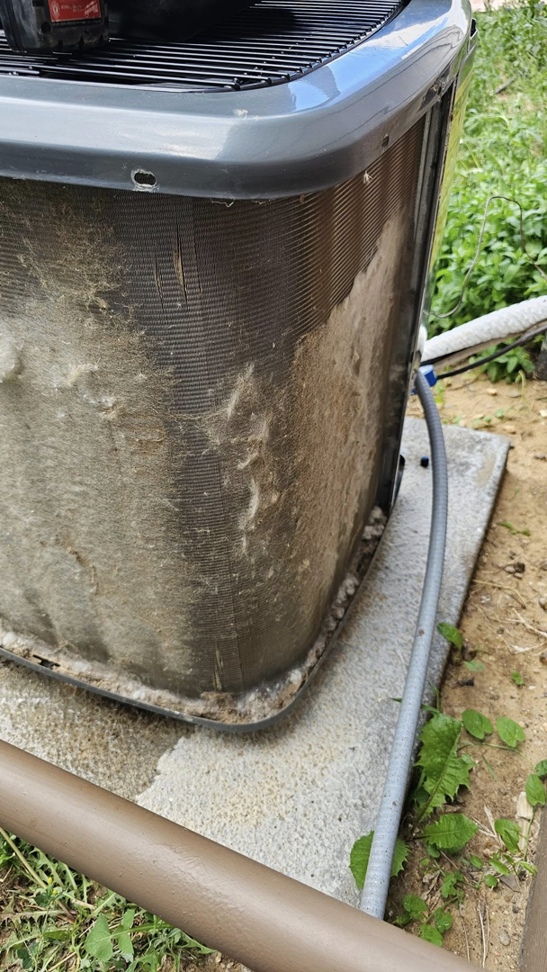 Close-up of dirty and clogged outdoor AC unit coils requiring maintenance from Erik's Quality HVAC LLC in Greeley, CO.
