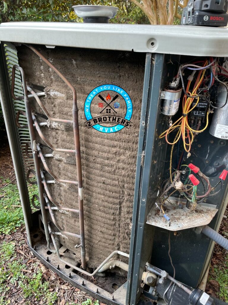 Very dirty condenser coils inside an outdoor AC unit, indicating a need for cleaning by 2 Brothers HVAC in Seguin, TX