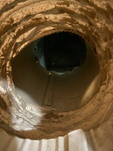 A very dirty air duct with significant dust and debris buildup, before cleaning by Clean Air Solutions in Gaithersburg, MD.