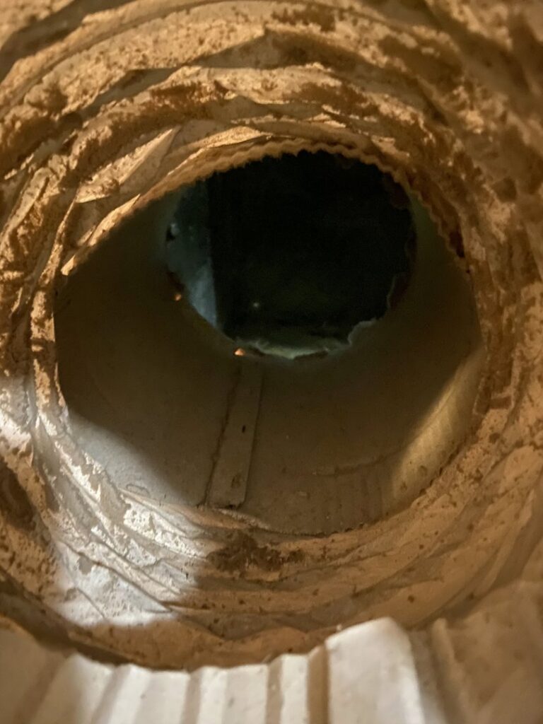 A very dirty air duct with significant dust and debris buildup, before cleaning by Clean Air Solutions in Gaithersburg, MD.