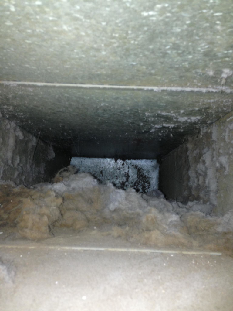 A heavily clogged and dirty air duct before cleaning by Richmond Restoration in Worcester, MA