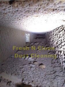 A view inside a very dirty air duct showing accumulated debris, indicating a cleaning service by Fresh N Clean Duct Cleaning in Arvada, CO.