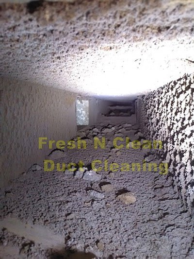 A view inside a very dirty air duct showing accumulated debris, indicating a cleaning service by Fresh N Clean Duct Cleaning in Arvada, CO.