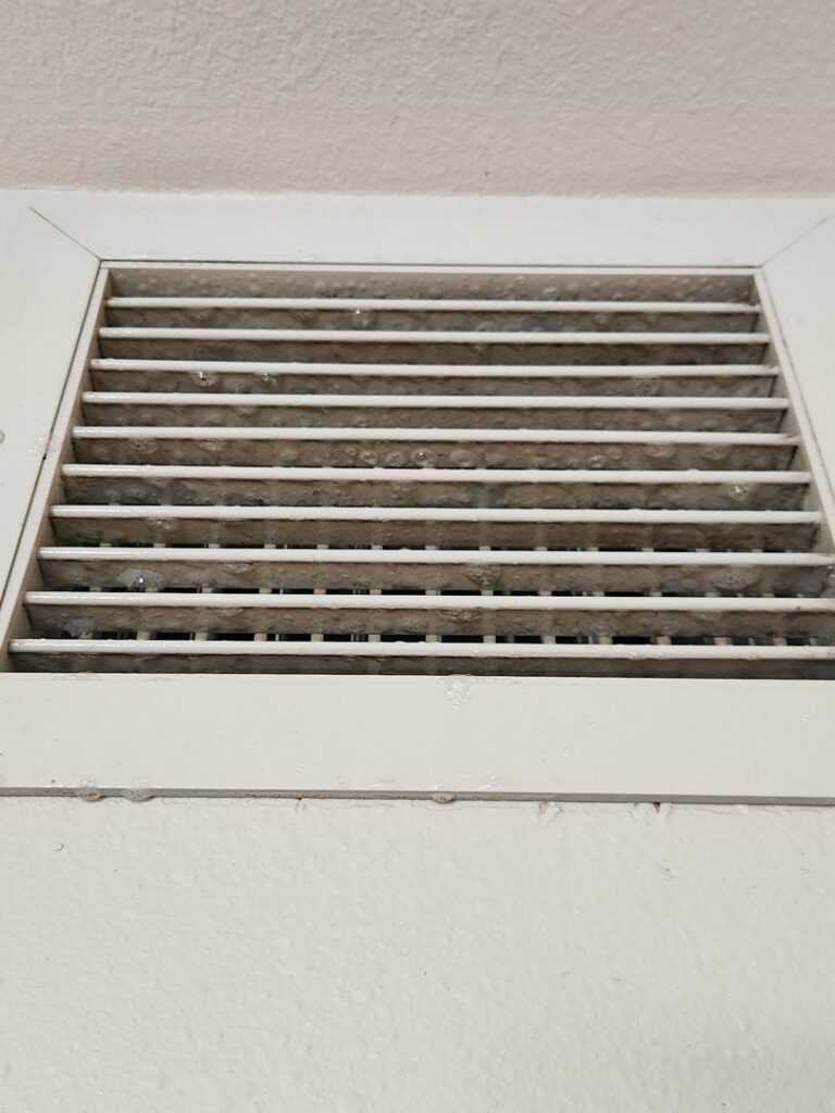 Close-up of a dirty air return vent grille covered in dust, showing a common issue addressed by DUCTZ of Siouxland in Vermillion, SD.