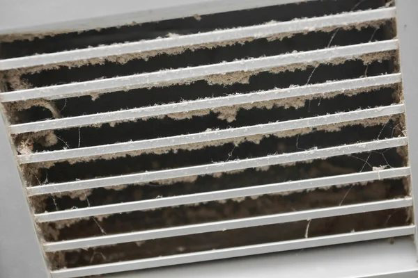 A close-up of a very dirty air vent grille with dust and cobwebs, showing need for HVAC service from Murray's General Services in Goose Creek, SC.