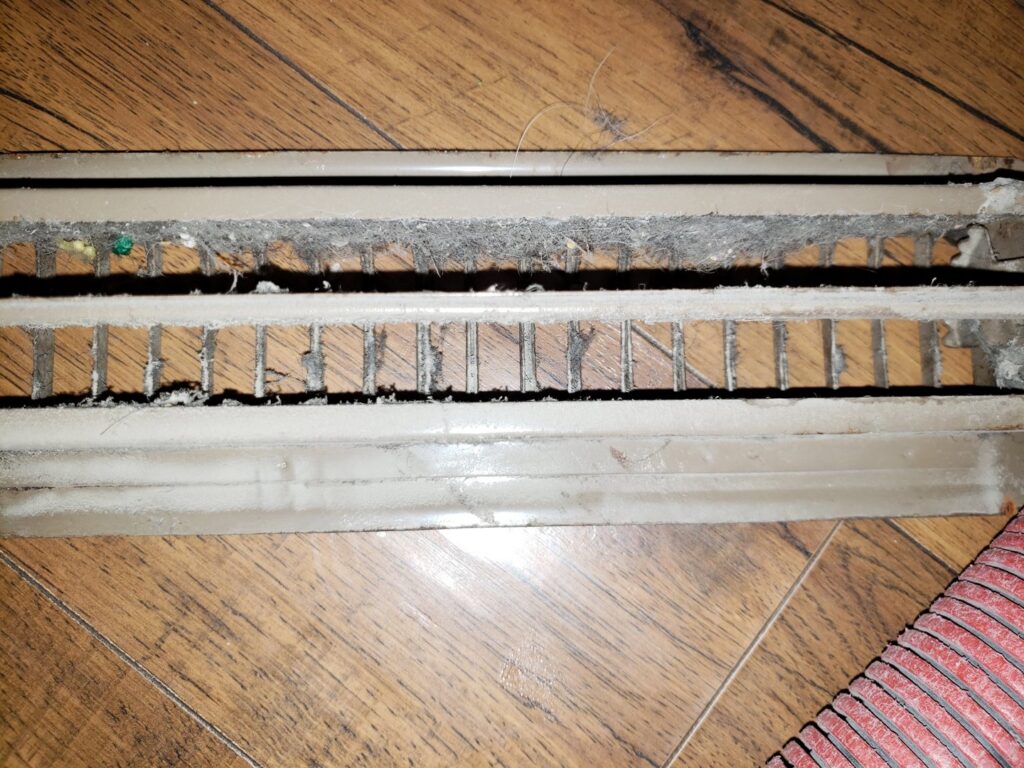A close-up of a dirty air vent register before cleaning by APEX Clean Air in South Salt Lake, UT.