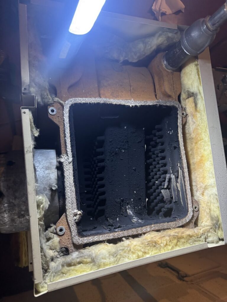 A dirty boiler combustion chamber showing soot buildup, indicating a need for HVAC maintenance from Leffler Energy in Lancaster, PA.