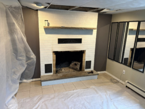 A dirty brick fireplace with protective plastic sheeting, ready for a sweep by Cozy Hearth Chimney in South Avington Township, PA.