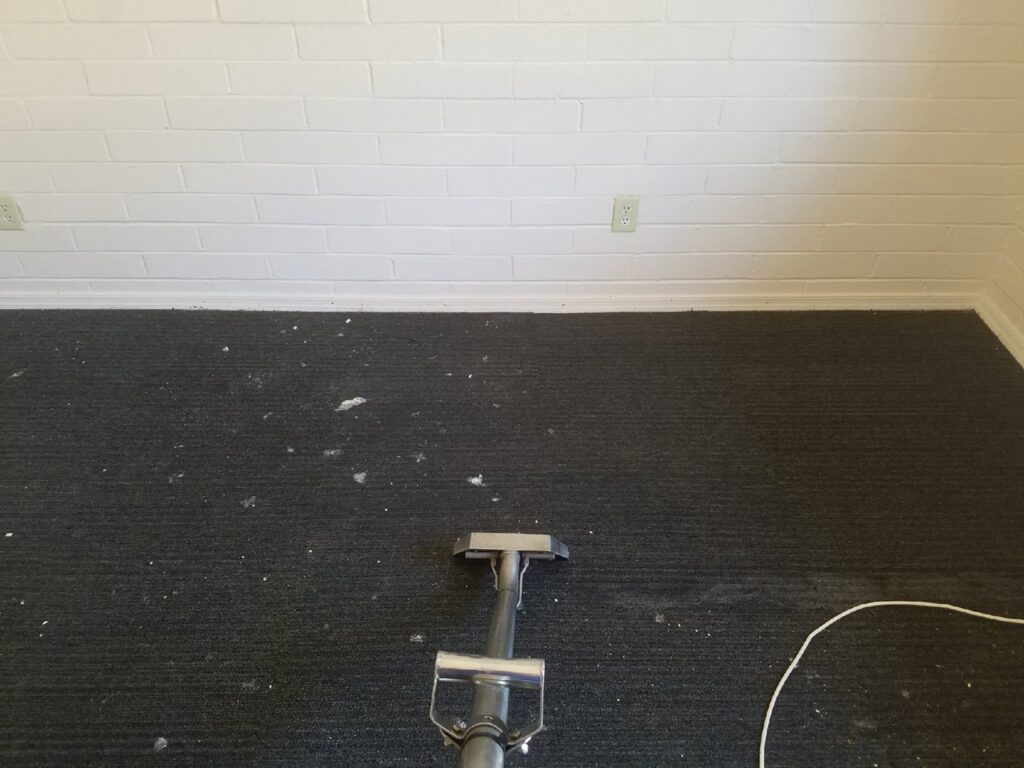 Cleaning a dirty dark carpet with white debris by Regal Carpet Cleaning Inc. in Tucson, AZ