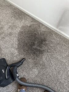 A dirty carpet with a dark stain, showing the need for professional cleaning by Musser's Advanced Carpet Care in North Kansas City, MO.