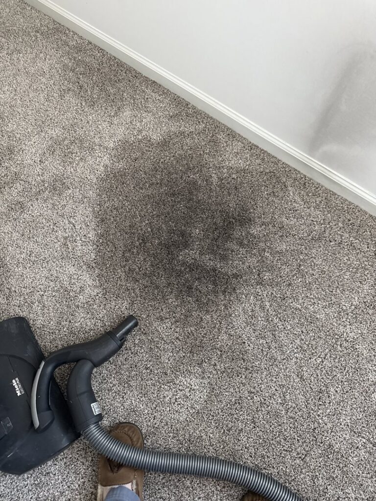 A dirty carpet with a dark stain, showing the need for professional cleaning by Musser's Advanced Carpet Care in North Kansas City, MO.