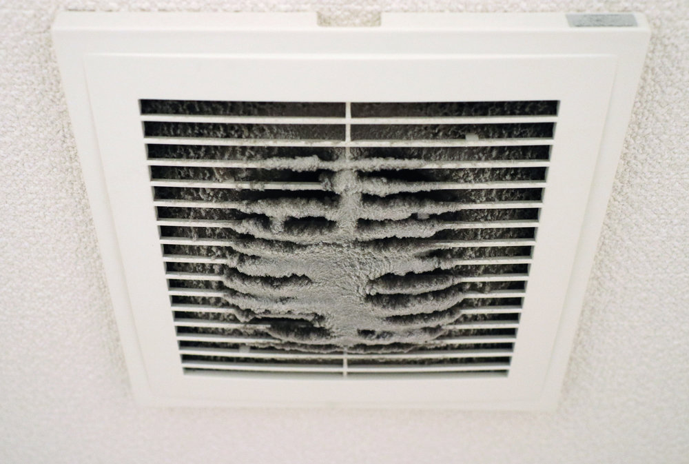 A dirty ceiling air vent or grille, heavily caked with dust, indicating the need for duct cleaning by Air Doctor Duct Cleaning & Lining in Tulsa, OK.