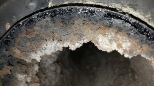 A close-up view inside a dirty chimney flue showing significant creosote buildup, indicating a need for sweeping by Chimney Karma in Fort Collins, CO.