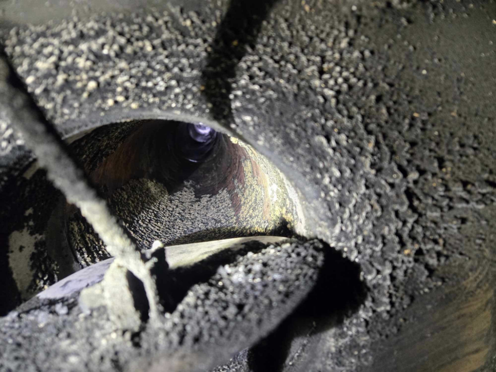 Dirty chimney flue with creosote buildup, showing need for a sweep by Griep Enterprises in Machesney Park, IL.