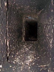 A close-up view of a dirty and sooty chimney flue opening with cobwebs, ready for cleaning by Chimney Cricket Cleaning Service in Marshfield, MO