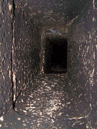 A close-up view of a dirty and sooty chimney flue opening with cobwebs, ready for cleaning by Chimney Cricket Cleaning Service in Marshfield, MO