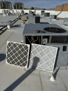 Dirty and clean HVAC air filters on a commercial rooftop unit by Rogue Mechanical in Las Vegas, NV.