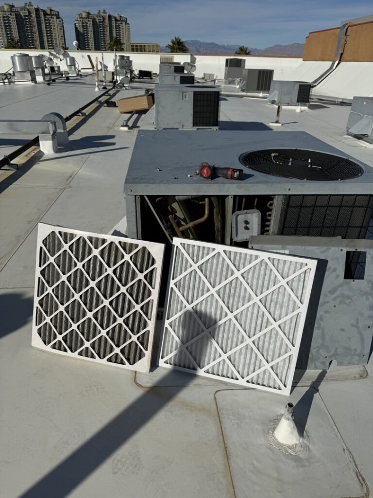 Dirty and clean HVAC air filters on a commercial rooftop unit by Rogue Mechanical in Las Vegas, NV.