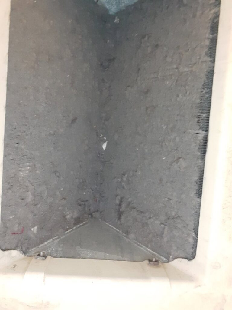 A dirty and clogged HVAC evaporator coil inside a unit, indicating a need for cleaning or service from Arrowseal of Billings HVAC in Billings, MT.