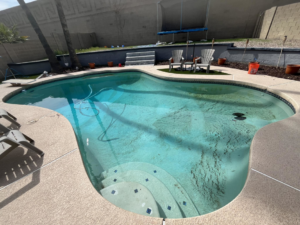 A dirty and cloudy swimming pool with debris on the bottom, indicating a need for service from Brigade Pool Services in Tempe, AZ.