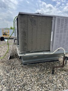 A dirty commercial rooftop AC unit, indicating a need for professional cleaning and maintenance by Radiant Heating & Cooling in Fishers, IN.