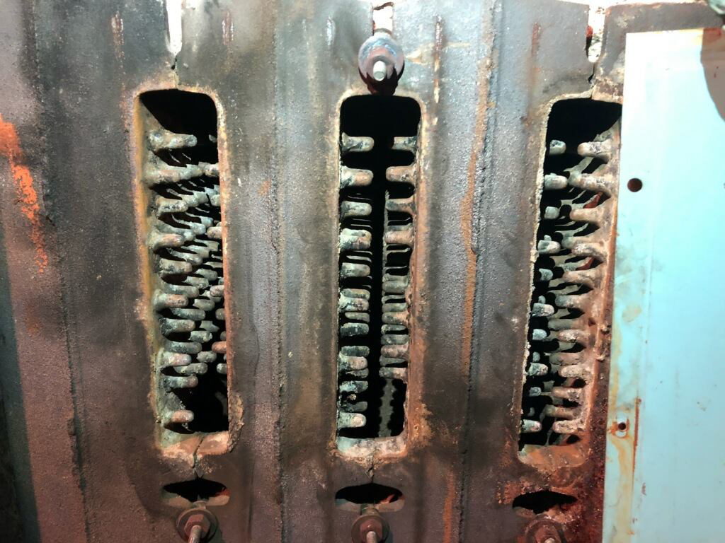 A close-up of a dirty and corroded furnace heat exchanger, an HVAC issue addressed by EH Gochnauer & Sons, Inc. in Lancaster, PA.