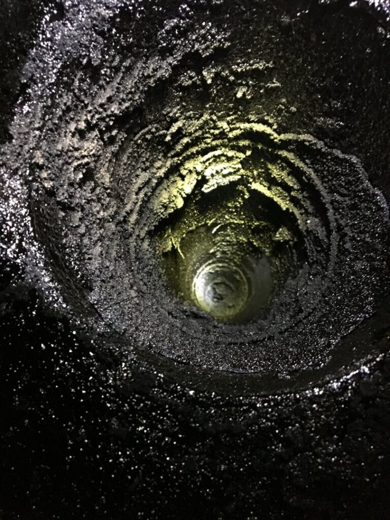 An interior view of a dirty, creosote-filled chimney flue, showing the need for a sweep by Northwest Chimney in Bremerton, WA.