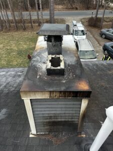 A heavily soiled and potentially damaged chimney cap and top of a chimney, indicating a need for service from Midtown Chimney Sweeps in Golden, CO.
