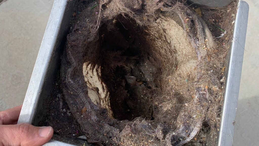 A dirty filter full of debris after a thorough carpet cleaning service by Soft N Dry in Tucson, AZ.