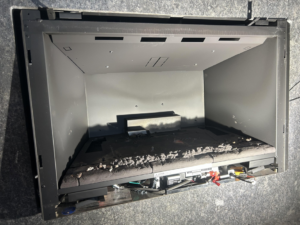 A very dirty fireplace insert filled with ash and debris, ready for a professional chimney sweep by Local Chimney Services LLC in Providence, MA.