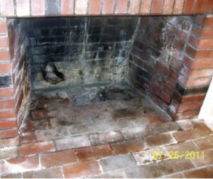 A dirty fireplace interior with soot and stains, indicating the need for a professional chimney sweep from Soot Masters Chimney Service LLC in Jackson, MS.
