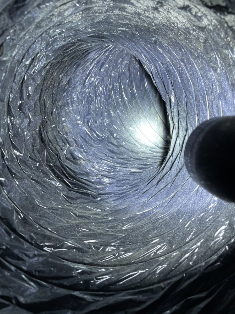 A view inside a dirty flexible air duct with accumulated dust, before cleaning by Vacman Air Duct Cleaning in South Bend, IN