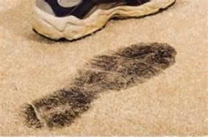 A clear image of a dirty footprint on a light-colored carpet, showing the need for cleaning by Servicemaxx in Indianapolis, IN.