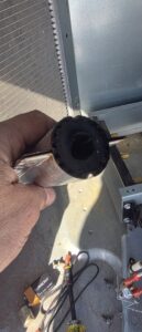 A technician holding a dirty furnace burner tube during service by By the Bay Mechanical in Prince Frederick, MD