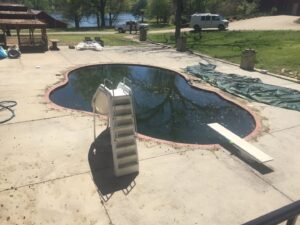 A very dirty, green swimming pool full of debris, awaiting cleaning by Alabama Pool Kings in Madison, AL.