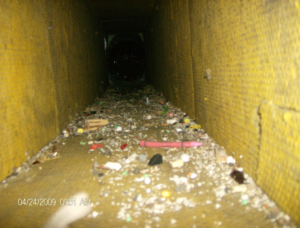 Interior view of a dirty HVAC air duct filled with debris, indicating a need for cleaning by Air Essentials in Madison, AL