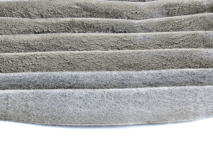 A close-up view of a dirty HVAC air filter, indicating the need for replacement by Request Heating & Cooling in Holland, MI