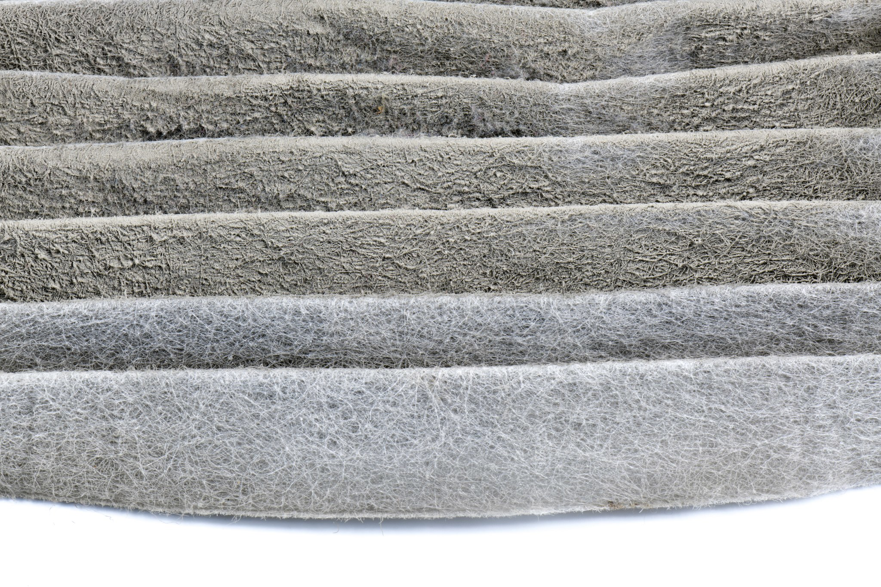 A close-up view of a dirty HVAC air filter, indicating the need for replacement by Request Heating & Cooling in Holland, MI