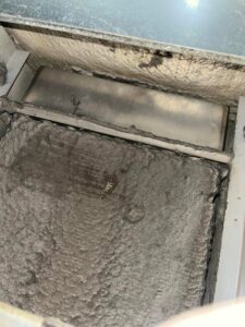 A severely dirty air filter or coil inside an HVAC duct, emphasizing the need for professional air quality and cleaning services from Greenley Heating & Cooling in Waterloo, IA