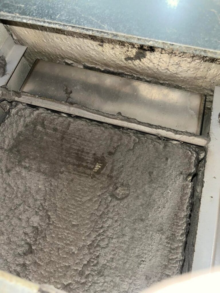 A severely dirty air filter or coil inside an HVAC duct, emphasizing the need for professional air quality and cleaning services from Greenley Heating & Cooling in Waterloo, IA