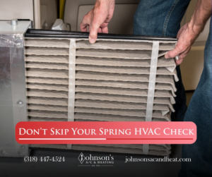 Hands holding a dirty HVAC air filter, showing a service need from Johnson's A/C & Heating in Alexandria, LA.