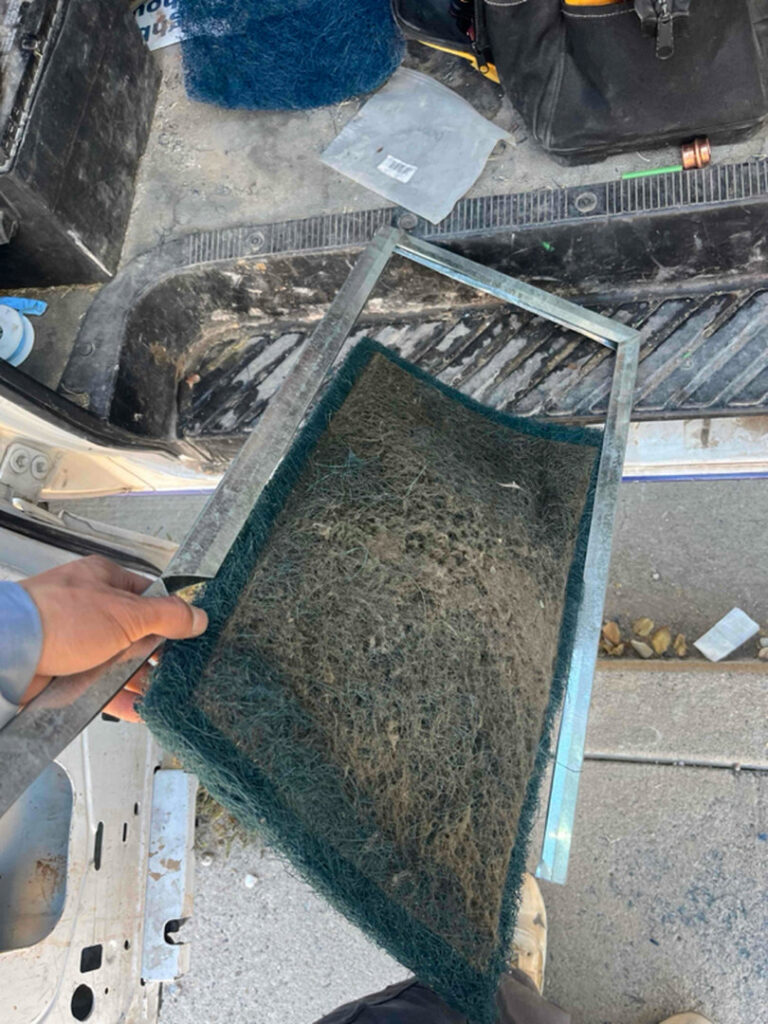 A technician holding a dirty HVAC air filter, indicating a need for replacement or cleaning by Number 1 Plumber in Washington, DC.