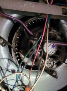 A close-up of a dirty HVAC blower motor and wiring, indicating a repair or maintenance job by ARKLA AIR LLC in Springhill, LA.
