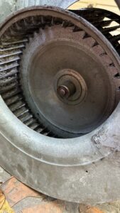 A close-up view of a dirty HVAC blower wheel, indicating the need for cleaning or maintenance by Comfort Pros in Mobile, AL.