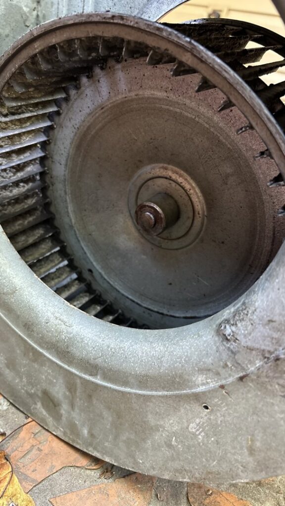 A close-up view of a dirty HVAC blower wheel, indicating the need for cleaning or maintenance by Comfort Pros in Mobile, AL.