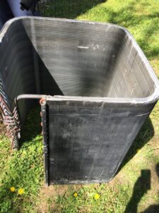 A dirty HVAC condenser coil, likely removed for cleaning or replacement, by Johnson's Heating and Cooling in Clarksville, TN.