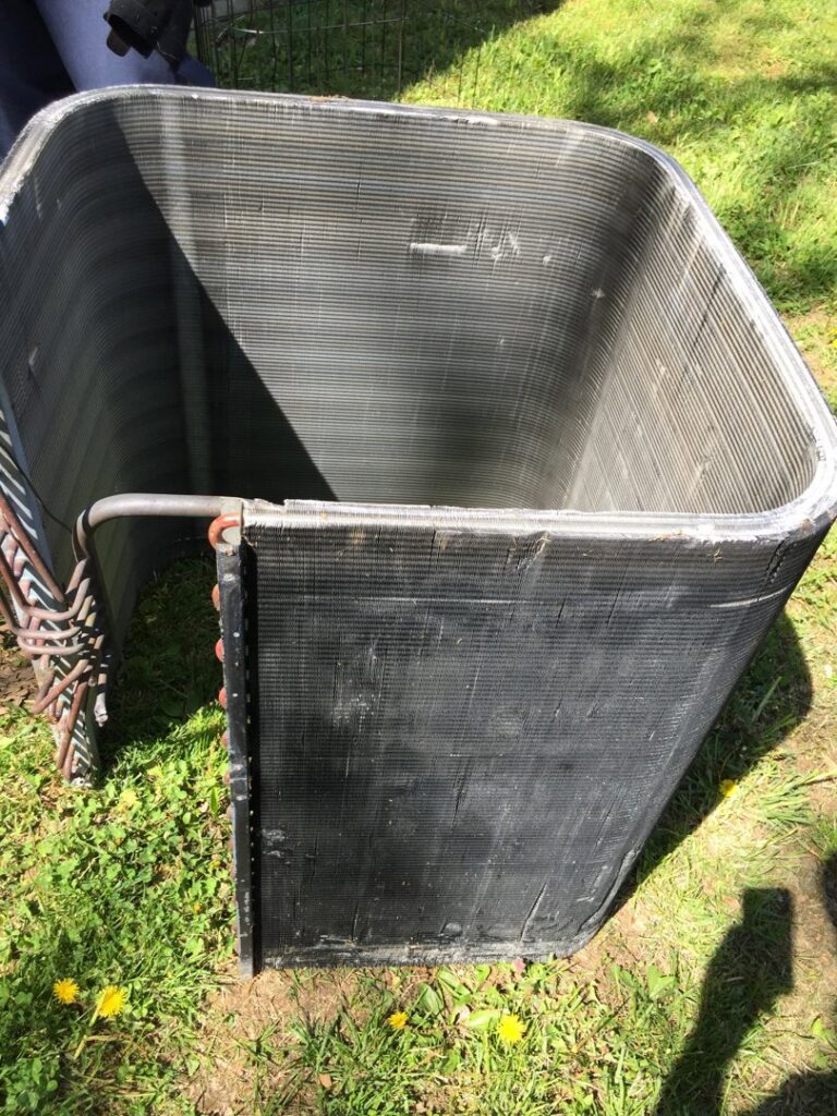 A dirty HVAC condenser coil, likely removed for cleaning or replacement, by Johnson's Heating and Cooling in Clarksville, TN.
