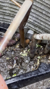A close-up of dirty HVAC condenser coils before cleaning by Arrow Pro Services in Gilbert, AZ